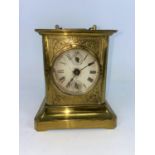 A 19th century American brass mantel / alarm clock in the style of a carriage clock