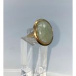 A 9 carat hallmarked gold dress ring set with oval jade coloured stone, size O1/2, 6.3gm