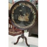 An early 19th century mahogany occasional table with circular tilt top, and inset needlework panel