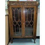 An Oak carved double astragal glazed display cabinet