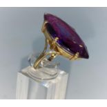 A yellow metal dress ring set with large marquise style amethyst, shank unmarked tests as 9/10
