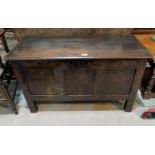An 18th century blanket box in framed and panelled oak with hinged lid, on block feet