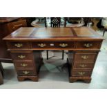 A reproduction mahogany kneehole desk with twin pedestals; an armchair