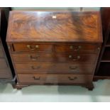 A Georgian figured mahogany fall front bureau with boxwood and ebony stringing, 3 long and 2 short