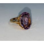 A yellow metal dress ring set with large oval amethyst, unmarked, size N, 6,5gm