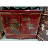 A Chinese double door side cabinet in red high gloss lacquer finish decorated with birds in