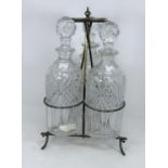 An Arts & Crafts silver plated triple decanter stand with 3 cut bottles