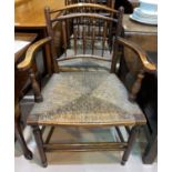 A 19th century elm country made armchair with rush seat and spindle back