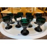A set of 9 ogee shaped green wine glasses