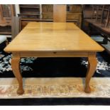 A large late 19th / early 20th century rectangular golden oak wind out dining table on cabriole legs