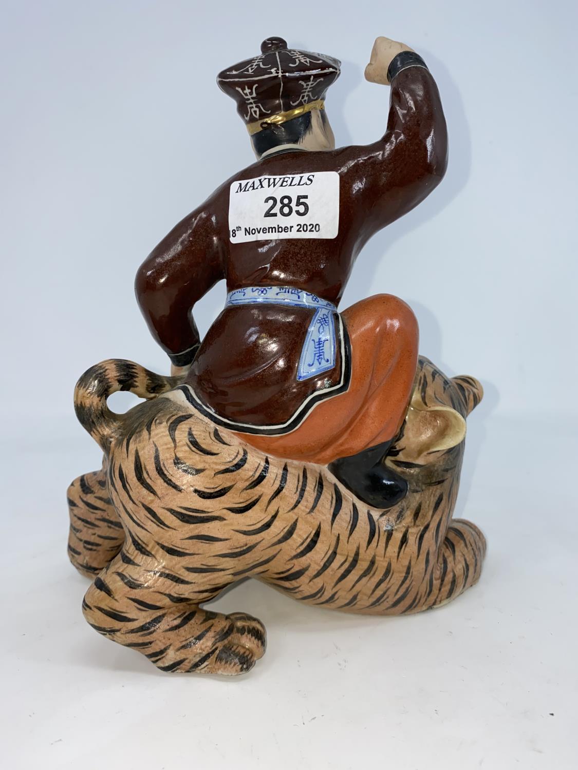 A Chinese ceramic figure of man seated on a tiger holding its tail, unmarked, height 21.5cm - Image 3 of 5