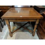 A 1930's oak draw leaf table on turned legs with cross stretcher