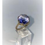 A lady's yellow metal dress ring set with a large circular Tanzanite, unmarked but tests as 9ct,