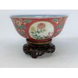A Chinese famille rose bowl with floral panel decoration to the outer and blue and white interior,