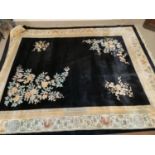 A large black ground Chinese carpet with floral decoration 460x370cm