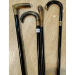 Four ebonised walking sticks with gilt metal collars, 3 with horn handles