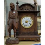 An Edwardian mantel clock in architectural oak case by Fattorini & Sons, Bradford; a carved wooden