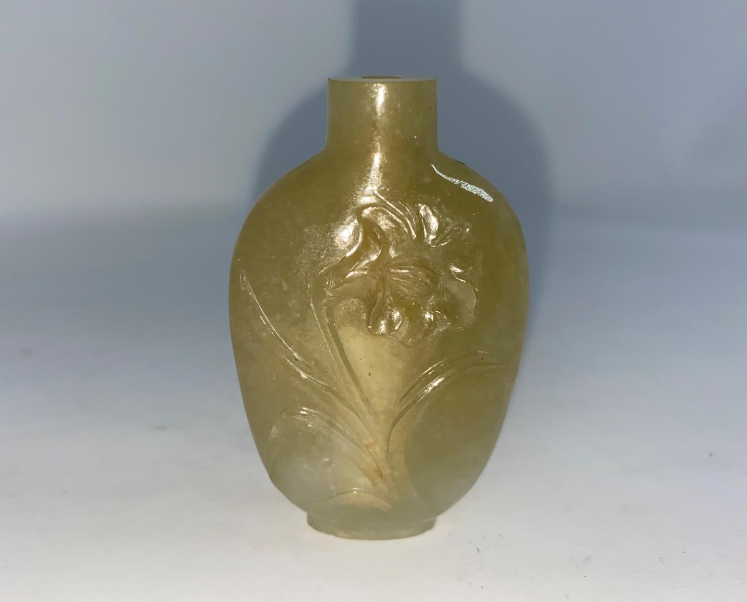 A Chinese carved hardstone snuff bottle with figures and scenery, 7cm; another jade coloured hard