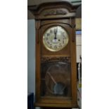 An Arts & Crafts wall clock, with strike, in carved oak case