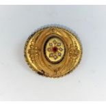 A Victorian oval filigree brooch set ruby and seed pearl, in yellow metal stamped '9c', 5.5 gm
