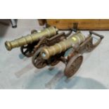 A pair of brass miniature cannons on cast iron gun carriage