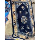 A Chinese rug with floral pattern on a dark blue ground, length 186 cm; a similar rug, length 130 cm