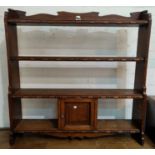 A 1930's 4 height wall shelf with small cupboard in beaded golden oak