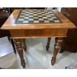 A Victorian walnut games table with rectangular inlaid chessboard top and fitted interior, on turned