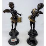 A pair of modern bronze figures: cherubs with drum and cymbals respectively, on grey marble
