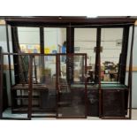 A large early 20th century shop display case with mirror backs plate glass shelves enclosed by s