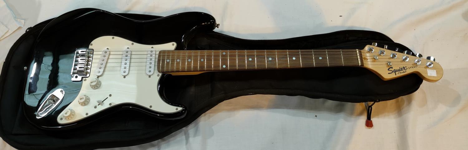 A FENDER Squire STRAT electric guitar, black body, rosewood neck with TGI soft case