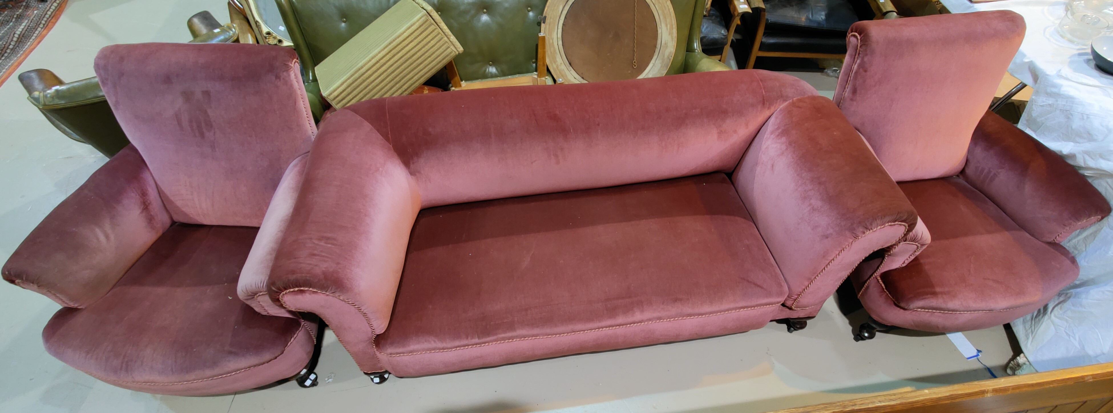 An early 20th century drop arm three seater settee, covered in pink draylon velvet and a pair of ma