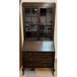 A 1930's oak bureau bookcase with twin glazed doors over fall front and 3 drawers, cabriole legs (