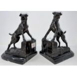 A modern bronze pair of bookends in the form of dogs, on grey marbled plinths, height 19 cm