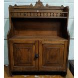 An Edwardian oak wall cabinet with double cupboard and galleried shelf under