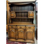 A 'Royal Oak' reproduction oak Welsh dresser with 3 drawers and 3 cupboards with carved panel