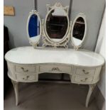 A French style white and gilt kidney shaped dressing table with triple mirror and five drawers