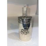 An Edwardian hall marked silver cylindrical scent bottle embosed with cherubs with glass liner and