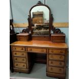 A Victorian mahogany kneehole dressing table with 9 drawers below and 4 above