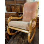 A Victorian mahogany rocking armchair with scroll arms, dusky pink upholstery