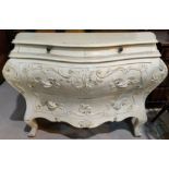 An early 20th century Italian bombe commode of 2 long and 2 short drawers, with carved decoration,