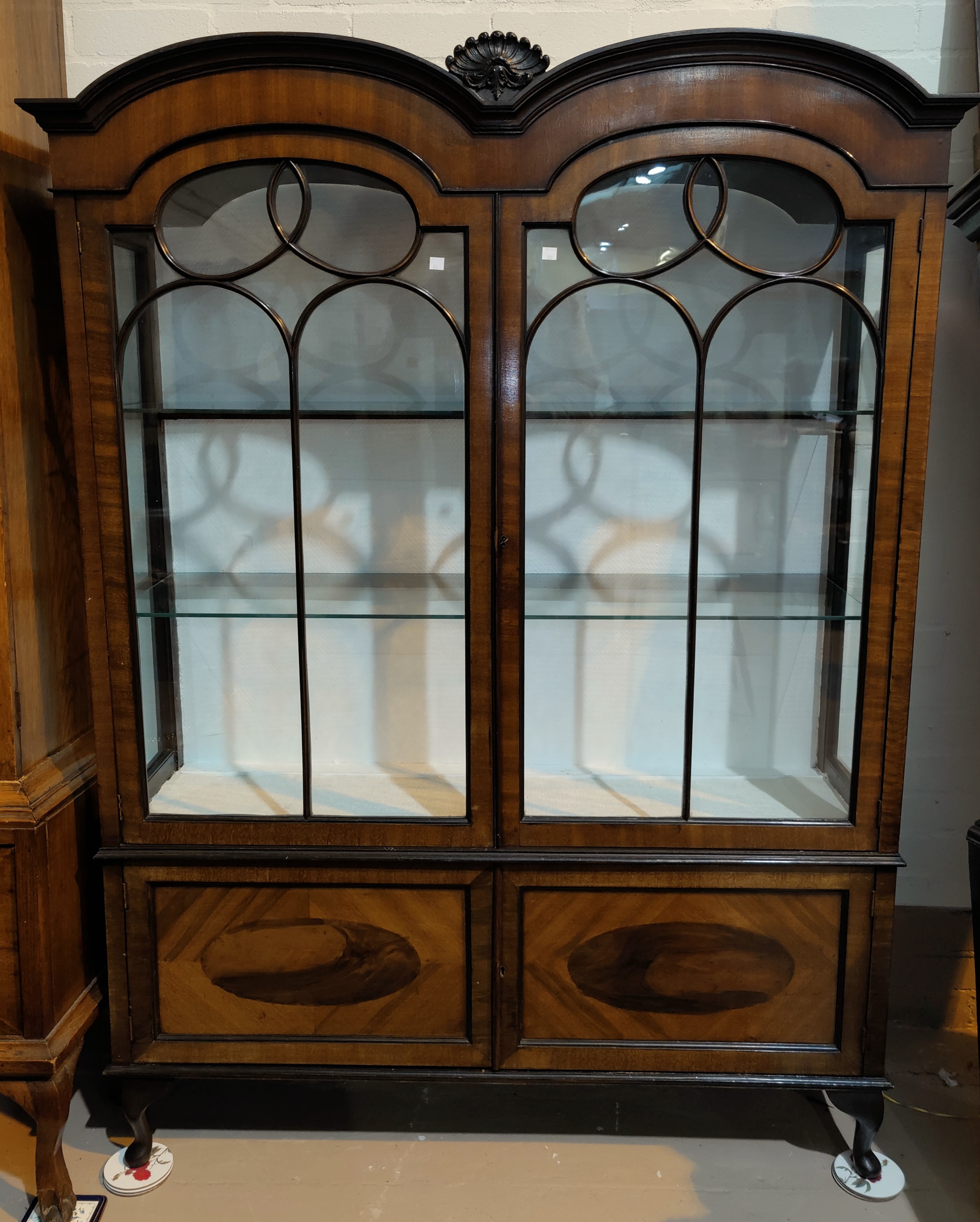 A 1920's mahogany display cabinet with double dome top, on cabriole legs
