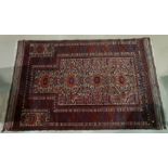 An early/mid 20th century Persian hand knotted prayer rug with red ground, 4 floral medallions and