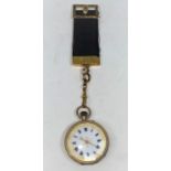 A 9 carat hallmarked gold fob watch, open faced and keyless, on black silk strap with yellow metal
