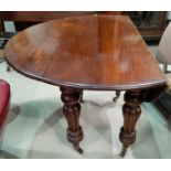 A Victorian drop leaf dining table in figured mahogany on heavy turned reeded legs