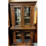A Victorian walnut display cabinet with double doors above and bellow, with mirror back
