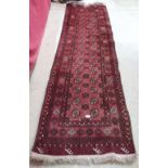 A red ground Afghan runner. 108' x 32'