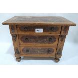 A 19th century painted pine miniature chest of three long drawers on turned feet. Continental. 11'