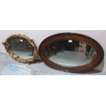 An oak oval wall mirror and a gilt plaster framed example