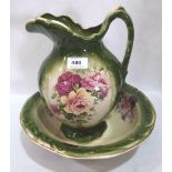 A Staffordshire washstand jug and bowl, transfer decorated with rose sprays on a green ground
